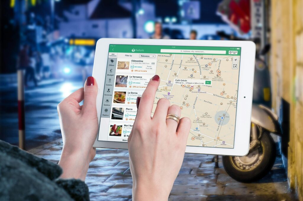 ipad-map-tablet-internet-38271-38271 Hands using a digital map on a tablet in an urban setting at night, illustrating navigation and technology.